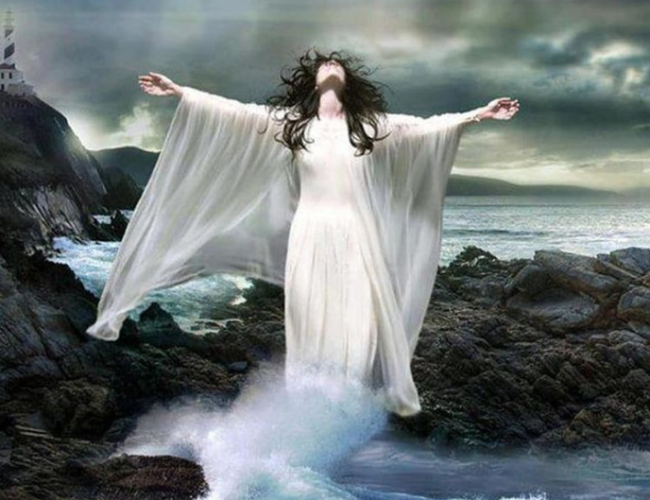 druidesse en robe blanche sur les récifs dans les vagues